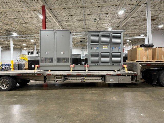 Power equipment loaded on a trailer with a worker in a safety vest